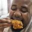 black man eating chicken