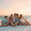 family on beach in sand on towel